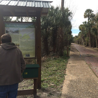 A man reads the informational sign at Pershing Highway Interpretive Trail