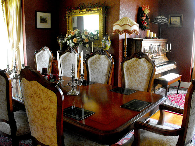 Antique Victorian dining table, chairs and piano in dining room