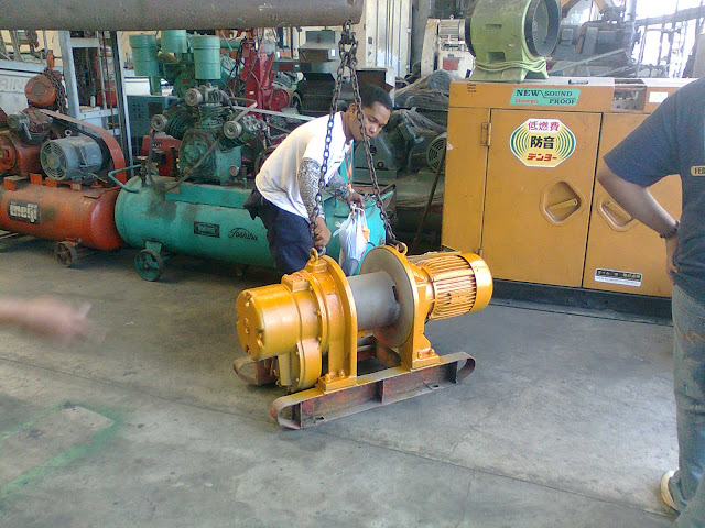 A mechanic lifting a motor