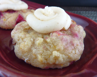 Cranberry Orange Cookie topped with Browned Butter Frosting, photographed on a burgundy plate.