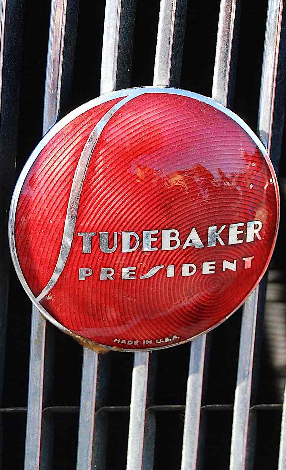 a close up photograph of a 1936 Studebaker President emblem