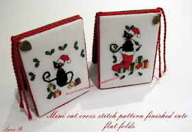 Cross stitch ornaments finished into flatfolds showing Mini Black Cats wearing a Santa hat with parcels and one black cat sitting in a christmas stocking.  