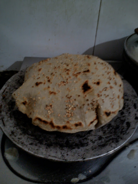 A bowl containing flour topped with seeds, resting on a table, representing the essence of Bhogi Bhakri.