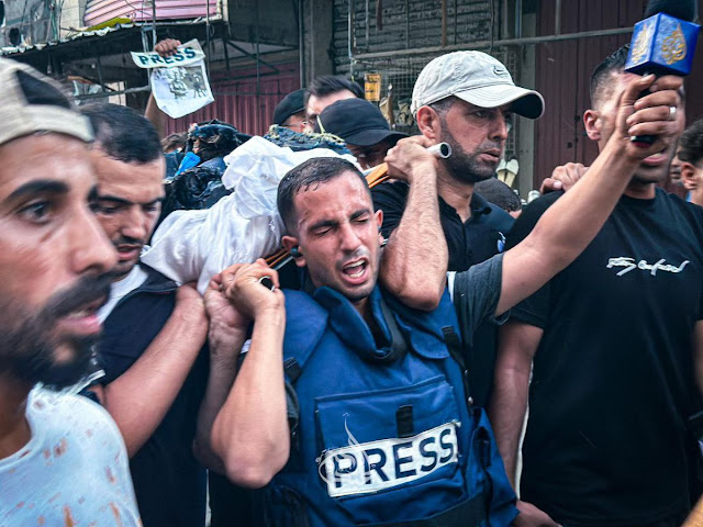 Al-Sharif carrying both Al Jazeera mic and his buddy's body