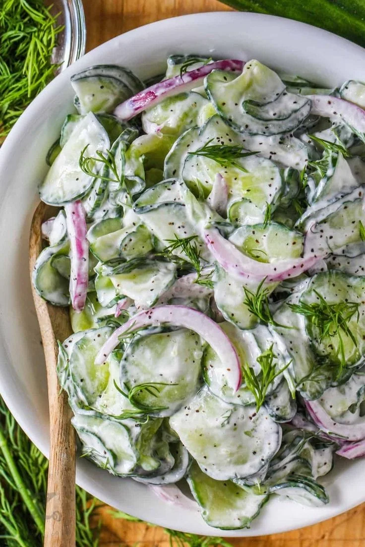 Healthy creamy cucumber salad served in a bowl with fresh ingredients