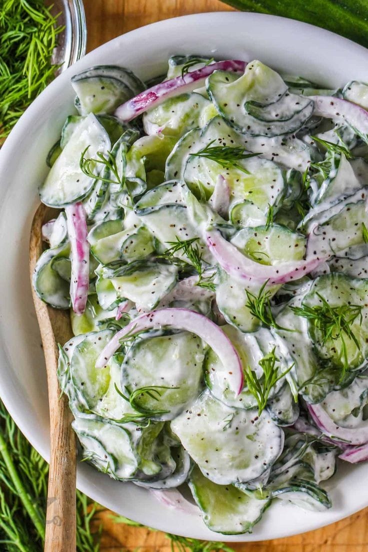 Healthy creamy cucumber salad served in a bowl with fresh ingredients