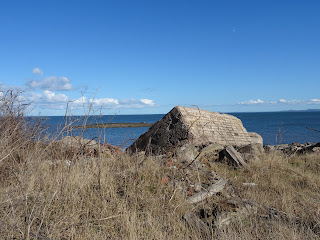 A view of a large bricked concrete block lying in scrubland - the sea stretches out behind it.  Photo by Kevin Nosferatu for the Skulferatu Project.