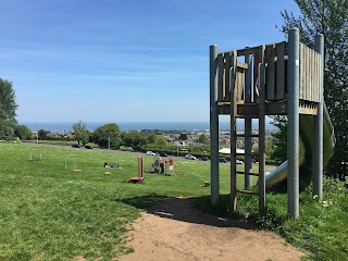 A silver tube slide in a park overlooking the Firth of Forth.