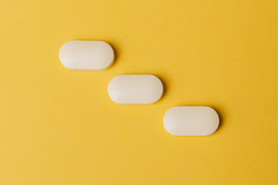 A set of pills on a yellow surface