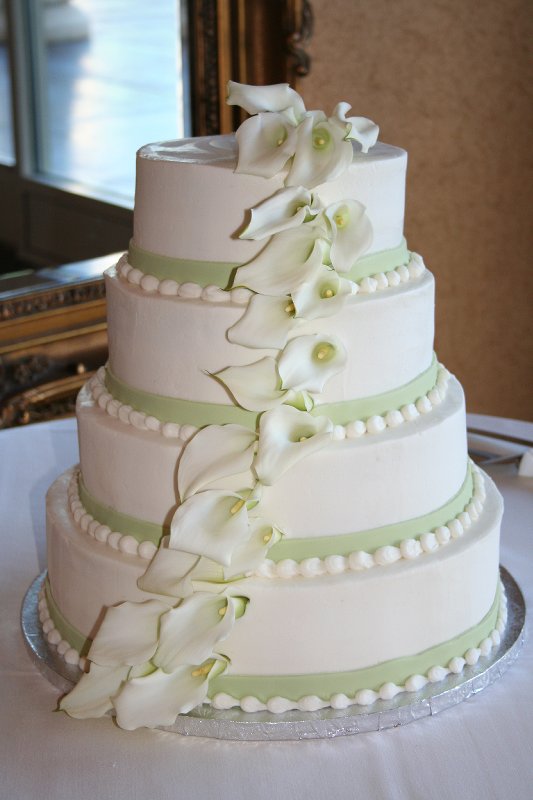 Simple three tier round white wedding cake decorated with green polka dot