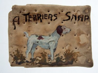 A ration biscuit with a painted illustration of a dog