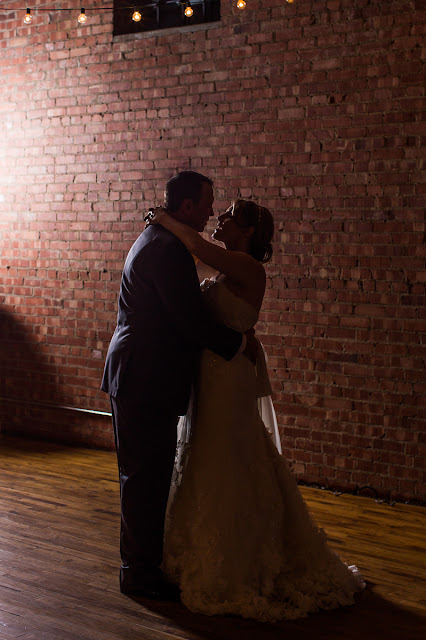 The bride and groom's first dance in sihlouette.  The ceremony is complete, and now they can relax in each other's arms.  They are now husband and wife having their first dance together.  Set at the Hall at the Railhouse located in Norman, OK during the fall of 2016.