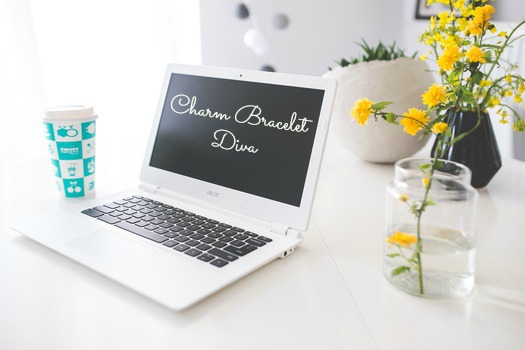 Laptop on desk with yellow flowers and coffee cup