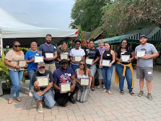 Corcoran Management Company employees posing with their 5 year plaques at Kimball Farm