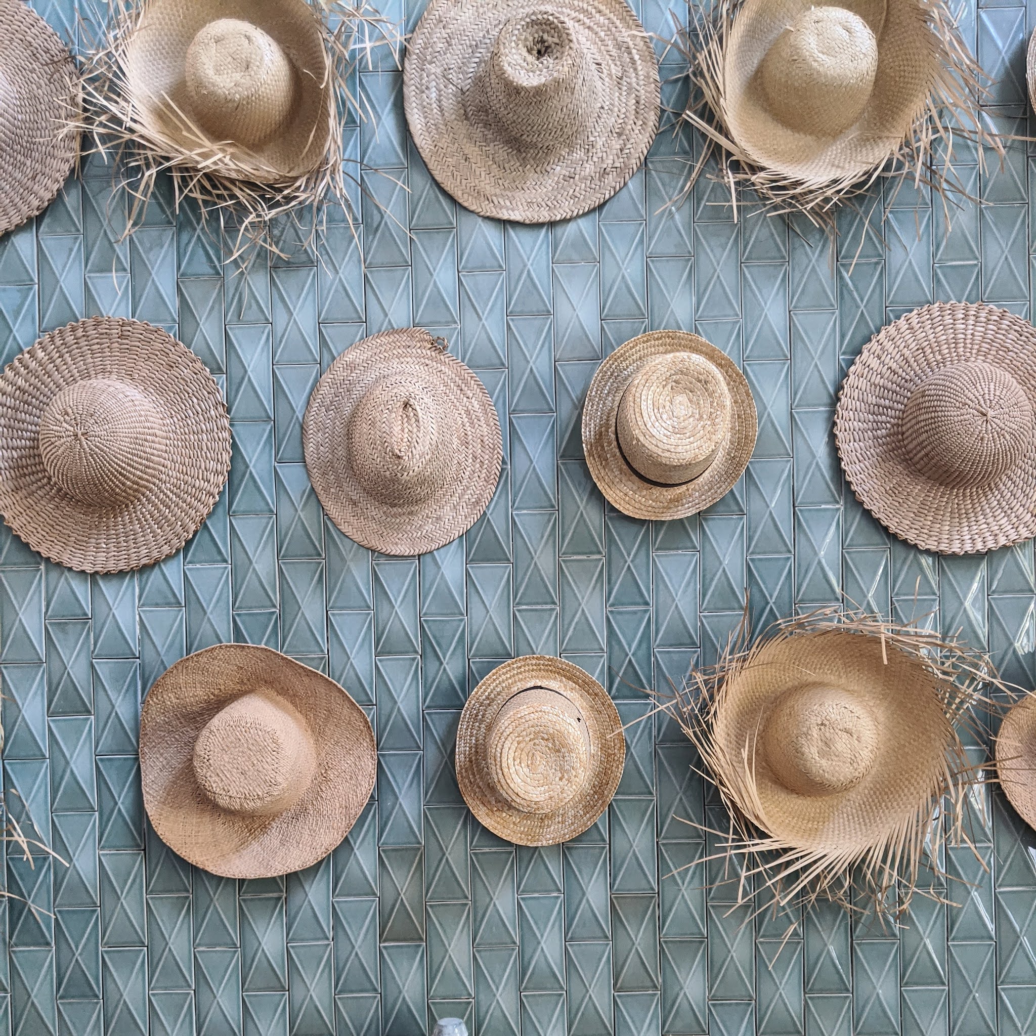 hats hanging on tiled wall at Menorca experimental