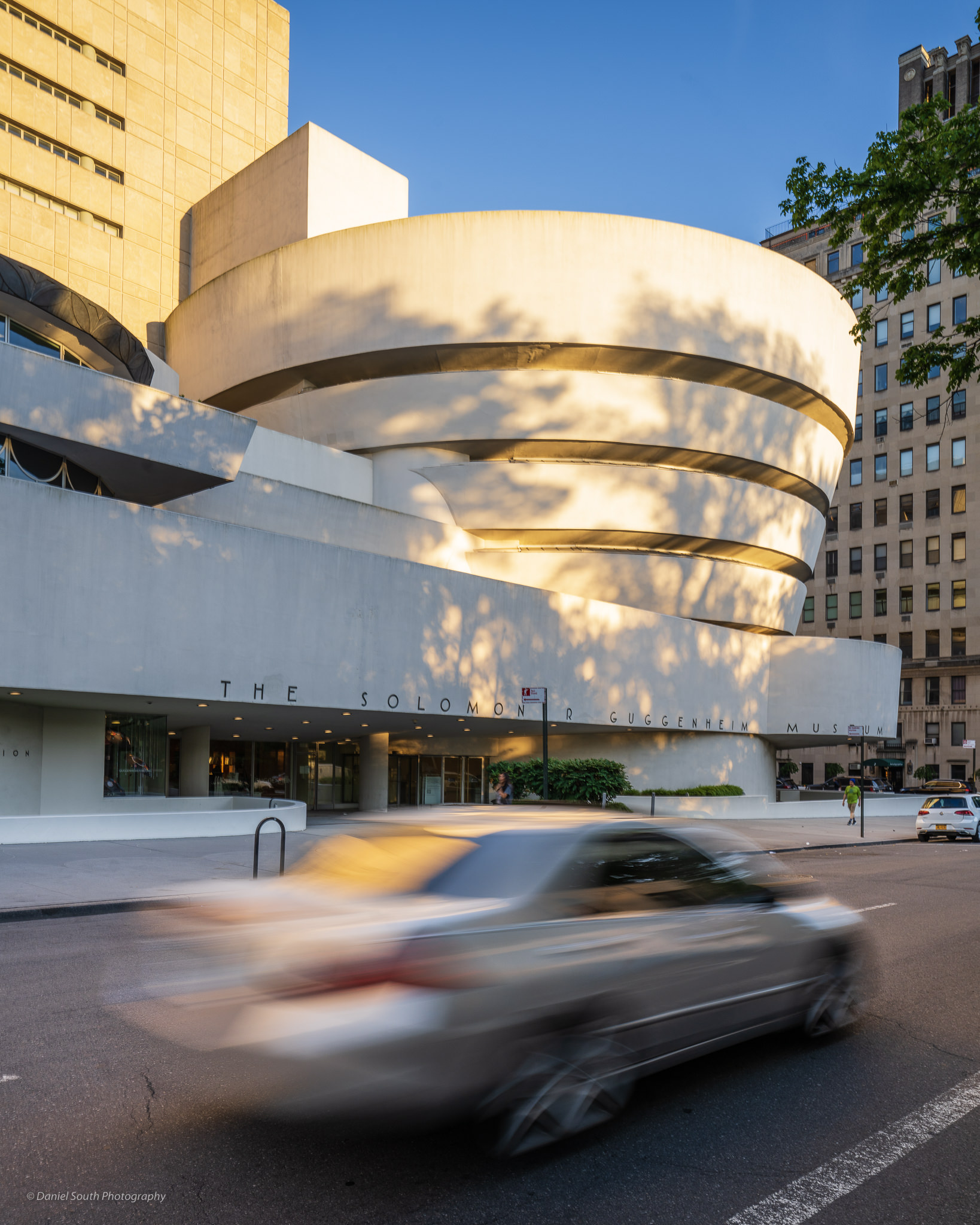 a photo of the guggenheim museum in new york with a speeding car
