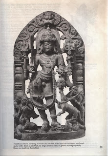 Virabhadra-Shiva, carrying a sword and trident, with head of Daksha in one hand and a rattle-drum in another his dogs and his army of ghouls accompany him; Stone carving from Karnataka 