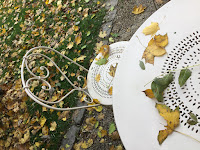 Photo by Sheila Webber: chair and table covered with autumn leaves in the gardens of the Musee Montmartre, November 2023