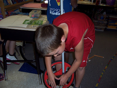 A student is working with the measuring wheel.