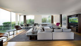 Large modern living room with white furniture and floor to ceiling windows
