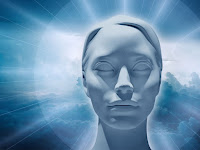 An all white sculpted female head with hair pulled back and eyes serenely closed. There is soft blue and white clouds behind her head and soft white rays of light emitting from her head.