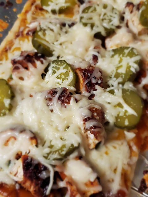 Flatbread with bbq chicken, pickles, bbq sauce, cheese and onion