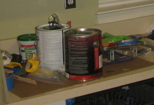 kitchen counter full of paint supplies for a makeover