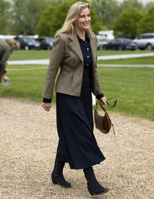 The Duchess of Edinburgh wore a navy ponte fit flare midi dress by ME+EM, and carries brown leather handbag by Isabel Marant