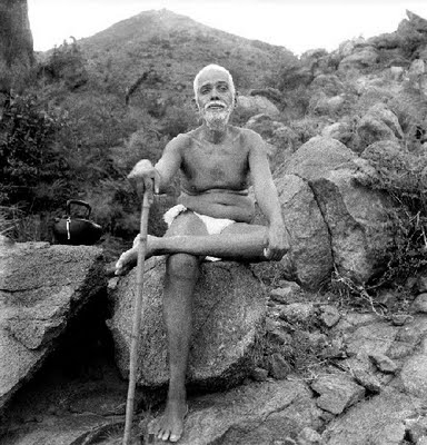 Bhagavan Sri Ramana Maharshi seated majestically on a rock of Arunachala