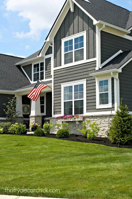 Dark gray house with white trim, stone and columns