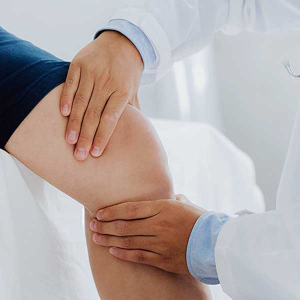 physician looking at patients knee