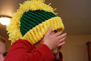 boy with hands up on face wearing a knit mohawk hat