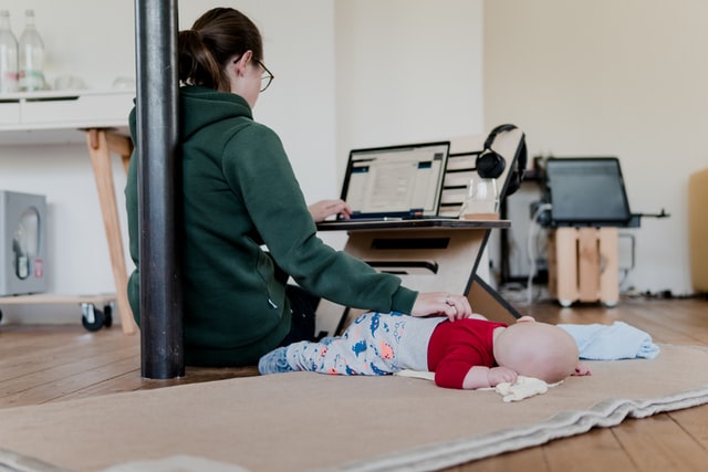 mulher em seu home office acariciando seu bebê