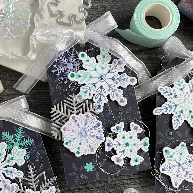 Ombre stamped snowflake tags created with: Scrapbook.com dainty snowflakes stamp and die set, peppermint patterned paper, solar white cardstock, pops of color lavender luster royal blue teal twinkle snowflake, snowflakes die, glitter metals paper; Tim Holtz distress oxide salvaged patina shaded lilac, faded jeans