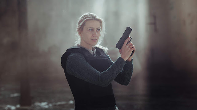 female detective holds a gun