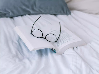 Book in bed with glasses