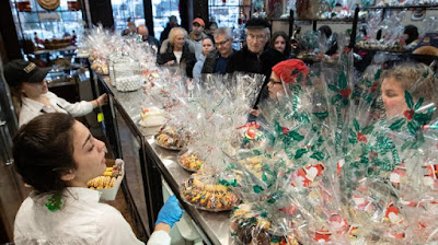 Puluhan Orang Berbaris di Luar Ttoko Roti Untuk Mengambil Hadiah Natal mereka