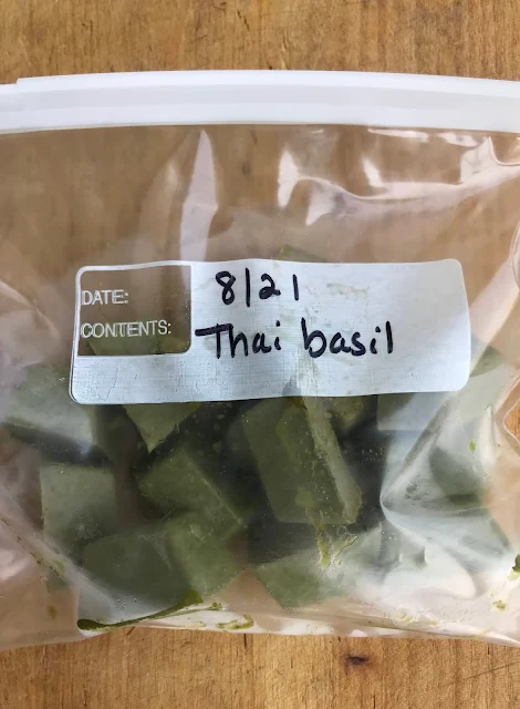 Frozen Thai basil cubes in a labeled frzzer bag.