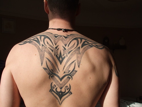 Many people like to combine cross and tribal tattoos to create a band of