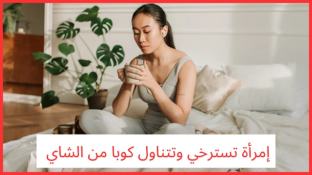 امرأة تسترخي وتتناول كوبًا من الشاي لتحسين حالتها المزاجية أثناء التغيرات الهرمونية