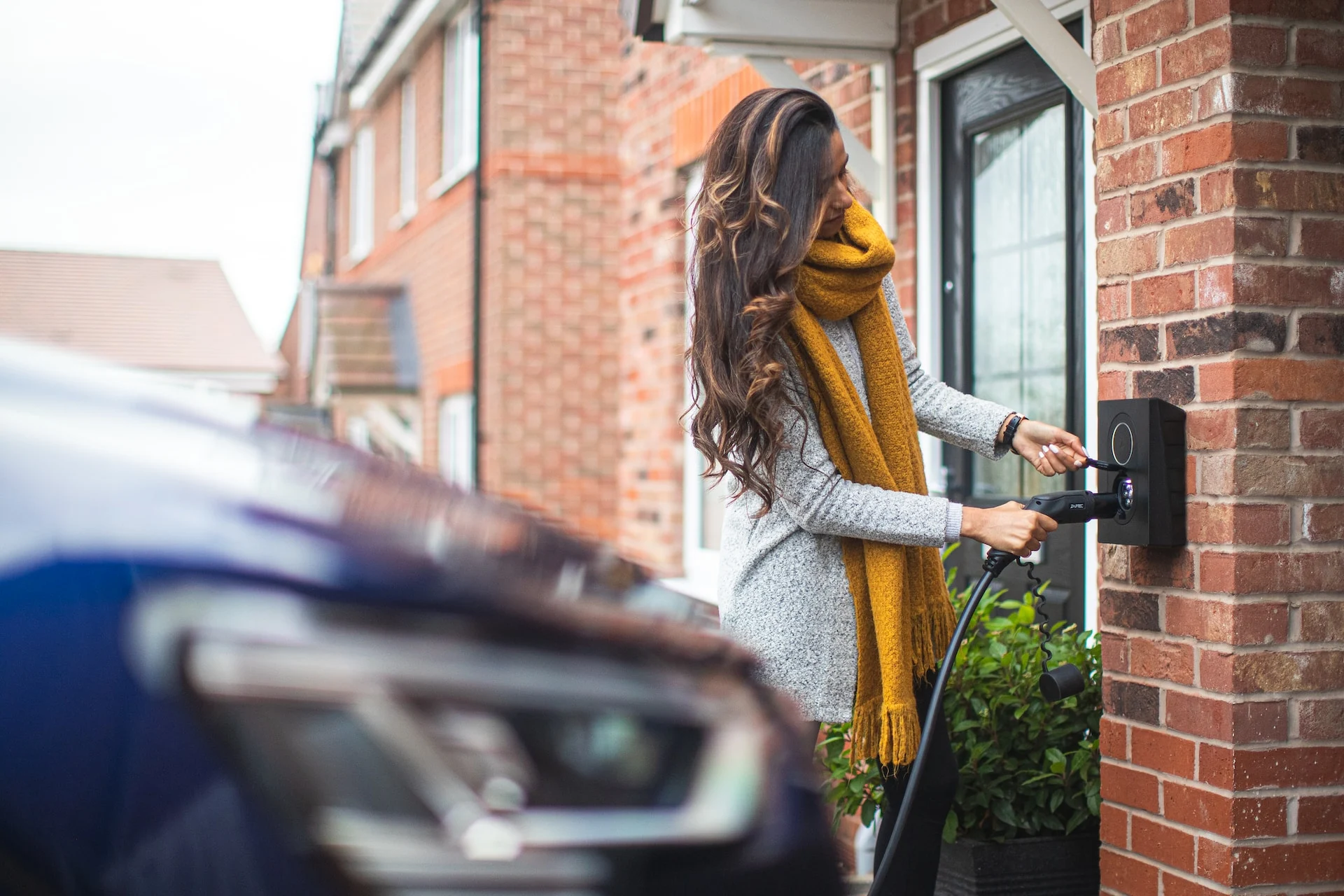 A female charging her EV car by herself free stock photo