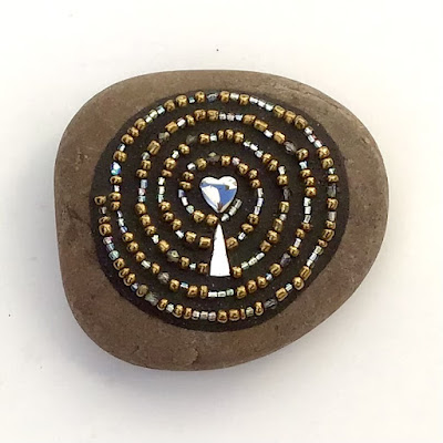 Mosaic on stone by Sue Betanzos.com. Glass beads repeat a spiral of I LOVE YOU in Morse code.