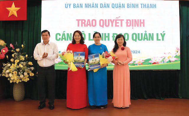 Đồng chí Thái Thị Hồng Nga và đồng chí Lương Nguyễn  Quốc Hải trao quyết định, tặng hoa chúc mừng  các đồng chí được điều động, bổ nhiệm. (Ảnh: AH)