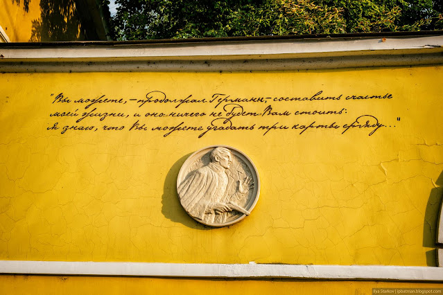 Барельеф мужчины и надпись на желтой стене