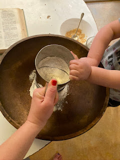 little hands helping mom sift flour into the bowl