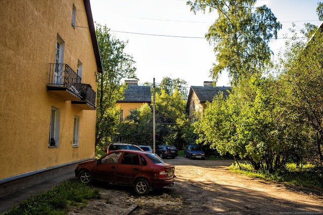 Припаркованные машины у двухэтажных зданий