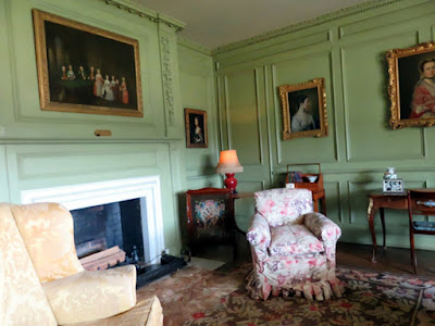 sitting room with overstuffed chair and green paneled walls