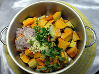 Pumpkin is ready in a pan with onion,  green and red chily, garlic, ginger, curry leaves.