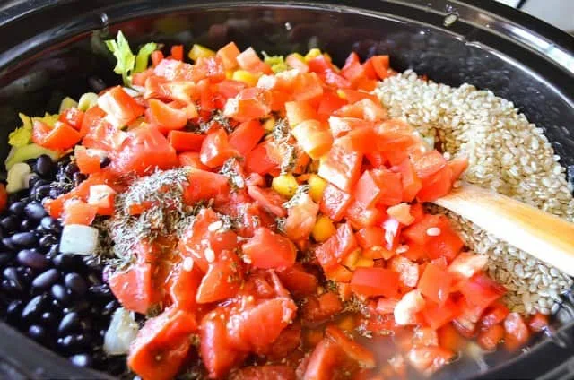 Crock Pot with Black Beans, Brown Rice, Garlic, Tomatoes, Bell Pepper, Herbs for Black Beans and Rice with Sausage.