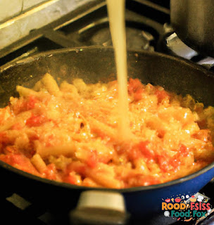  Image of crushed tomatoes being poured into the skillet. 